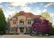 Elegant brick home featuring a stone facade, manicured lawn, and mature landscaping at 3053 Cambridge Hill Dr, Dacula, GA 30019
