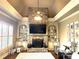 Elegant living room with a stone fireplace, built-in shelving, and large windows with plantation shutters at 3053 Cambridge Hill Dr, Dacula, GA 30019