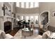 Bright living room featuring a grand piano, fireplace, and expansive windows offering plenty of light at 3053 Cambridge Hill Dr, Dacula, GA 30019