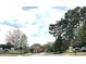 Elegant brick home nestled in Cambridge community, featuring mature trees and manicured landscaping at 3053 Cambridge Hill Dr, Dacula, GA 30019