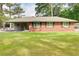 Charming single-story brick home with a well-maintained lawn, covered porch, and mature trees at 3221 Colquitt Dr, Atlanta, GA 30340