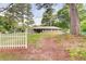 Quaint single-story home with a brick facade, surrounded by lush greenery and a charming white picket fence at 3221 Colquitt Dr, Atlanta, GA 30340