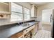 Kitchen sink under window with gray countertops and white tile floor at 3221 Colquitt Dr, Atlanta, GA 30340