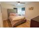 Cozy bedroom featuring a tufted headboard, warm lighting, and hardwood floors at 5085 Lake Dr, Forest Park, GA 30297