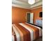 Bedroom with orange walls, tray ceiling, light fixture and furniture at 1246 Foxcreek Dr, Mcdonough, GA 30252