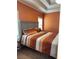Bedroom featuring orange walls, tray ceiling and a bed with colorful striped bedding at 1246 Foxcreek Dr, Mcdonough, GA 30252