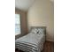 Bedroom features a neutral color, vaulted ceiling, and window providing natural light at 1246 Foxcreek Dr, Mcdonough, GA 30252