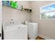 Bright laundry room featuring a washer, dryer, wire shelving, and natural light at 1246 Foxcreek Dr, Mcdonough, GA 30252