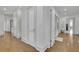 Well-lit hallway featuring hardwood floors, white doors, and a view into the exercise room at 2828 Peachtree Nw Rd # 3100, Atlanta, GA 30305