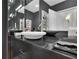 Chic powder room features a marble vessel sink, dark cabinets, mirrored walls, and modern lighting at 2828 Peachtree Nw Rd # 3100, Atlanta, GA 30305