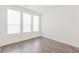 Bright bedroom featuring hardwood floors, three large windows, and white walls at 379 Pratt Se Dr # 408, Atlanta, GA 30315