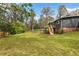 Large, grassy backyard with mature trees and a wooden deck, perfect for outdoor activities at 1185 Winterberry Ct, Lawrenceville, GA 30043