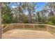 Outdoor deck with wooden railings, offering a serene view of the lush, green backyard at 1185 Winterberry Ct, Lawrenceville, GA 30043