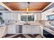 Well-lit kitchen with granite countertops, modern stainless steel appliances, white cabinets, and decorative tile flooring at 1185 Winterberry Ct, Lawrenceville, GA 30043