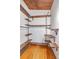 Open walk-in closet with custom shelving and wooden floors at 1185 Winterberry Ct, Lawrenceville, GA 30043