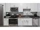 This kitchen features white cabinets, stainless steel appliances, and a grey backsplash at 1255 Branch Dr, Tucker, GA 30084