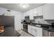 This kitchen features white cabinets, stainless steel appliances, and a grey backsplash at 1255 Branch Dr, Tucker, GA 30084