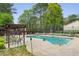 Community pool surrounded by lounge chairs, tables, and lush greenery for outdoor relaxation and entertainment at 1255 Branch Dr, Tucker, GA 30084