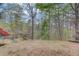 Scenic backyard with mature trees and a pond viewed from the hillside at 1343 Riverview Run Ln, Suwanee, GA 30024