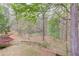 Scenic backyard with mature trees and a pond viewed from wooden deck at 1343 Riverview Run Ln, Suwanee, GA 30024