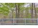 Scenic backyard with lush greenery and mature trees viewed from wooden deck at 1343 Riverview Run Ln, Suwanee, GA 30024