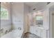 Bright primary bathroom featuring white cabinets, a luxurious soaking tub, and stylish finishes at 1343 Riverview Run Ln, Suwanee, GA 30024