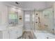 Bathroom featuring dual sinks, marble countertops, glass shower, and a jacuzzi tub at 1343 Riverview Run Ln, Suwanee, GA 30024
