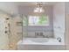 Bathroom featuring a luxurious soaking tub, tiled shower, and stylish finishes at 1343 Riverview Run Ln, Suwanee, GA 30024