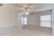 Bright bedroom features neutral carpet, a ceiling fan, and built-in cabinets at 1343 Riverview Run Ln, Suwanee, GA 30024