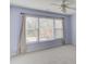 Bedroom with large windows, neutral carpet, blue walls, and a ceiling fan at 1343 Riverview Run Ln, Suwanee, GA 30024