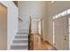 Welcoming foyer with hardwood floors, staircase with carpet runner, and a view into adjacent rooms at 1343 Riverview Run Ln, Suwanee, GA 30024