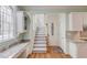 Hallway featuring a stairwell, a built-in desk with granite countertops, and neutral paint at 1343 Riverview Run Ln, Suwanee, GA 30024
