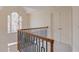 Hallway with iron railing, chandelier, and natural light from the arched window at 1343 Riverview Run Ln, Suwanee, GA 30024
