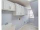 Laundry room with white cabinets, a sink, and tile flooring at 1343 Riverview Run Ln, Suwanee, GA 30024