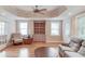 Bright living room with wood floors, tray ceiling, and ceiling fan at 1343 Riverview Run Ln, Suwanee, GA 30024