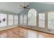 Bright sun room with many windows, ceiling fan, and hardwood floors overlooking the yard at 1343 Riverview Run Ln, Suwanee, GA 30024
