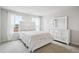Bright bedroom with a matching white bed and dresser complemented by natural light from the window at 156 Marchmont Dr, Locust Grove, GA 30248
