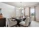 Elegant dining area with modern chandelier, large table with seating for eight at 156 Marchmont Dr, Locust Grove, GA 30248