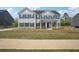 Charming two-story home with blue shutters, covered porch, and well-maintained lawn at 156 Marchmont Dr, Locust Grove, GA 30248