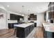 Spacious kitchen boasts black cabinets, a quartz island, and stainless steel appliances at 156 Marchmont Dr, Locust Grove, GA 30248