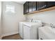 Laundry room featuring sleek appliances and a convenient sink, paired with stylish cabinetry at 156 Marchmont Dr, Locust Grove, GA 30248