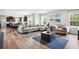 Open-concept living room features windows and a sectional sofa, perfect for relaxation at 156 Marchmont Dr, Locust Grove, GA 30248