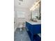Stylish bathroom with bright blue vanity, geometric tile floors, and glass shower at 770 Reed Se St, Atlanta, GA 30315