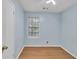 Bedroom featuring light blue walls, wood-look flooring, and a window with blinds at 1077 Mainstreet Valley Dr, Stone Mountain, GA 30088