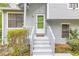 Charming home entrance featuring stairs, a bright green door, and gray siding at 1077 Mainstreet Valley Dr, Stone Mountain, GA 30088