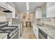 Galley kitchen boasts white cabinets, stainless steel appliances, and granite countertops at 1077 Mainstreet Valley Dr, Stone Mountain, GA 30088
