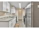 Modern kitchen features stainless steel appliances, white cabinets, granite counters, and vinyl floors at 1077 Mainstreet Valley Dr, Stone Mountain, GA 30088