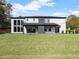 Expansive backyard featuring a modern home with large windows and a covered patio, creating an inviting outdoor space at 1688 Mineral Springs Rd, Hoschton, GA 30548