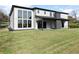 Expansive backyard with a covered patio, lush green lawn, and modern exterior finishes at 1688 Mineral Springs Rd, Hoschton, GA 30548
