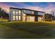 Expansive backyard view of the modern home featuring floor to ceiling windows and a well-manicured lawn at 1688 Mineral Springs Rd, Hoschton, GA 30548